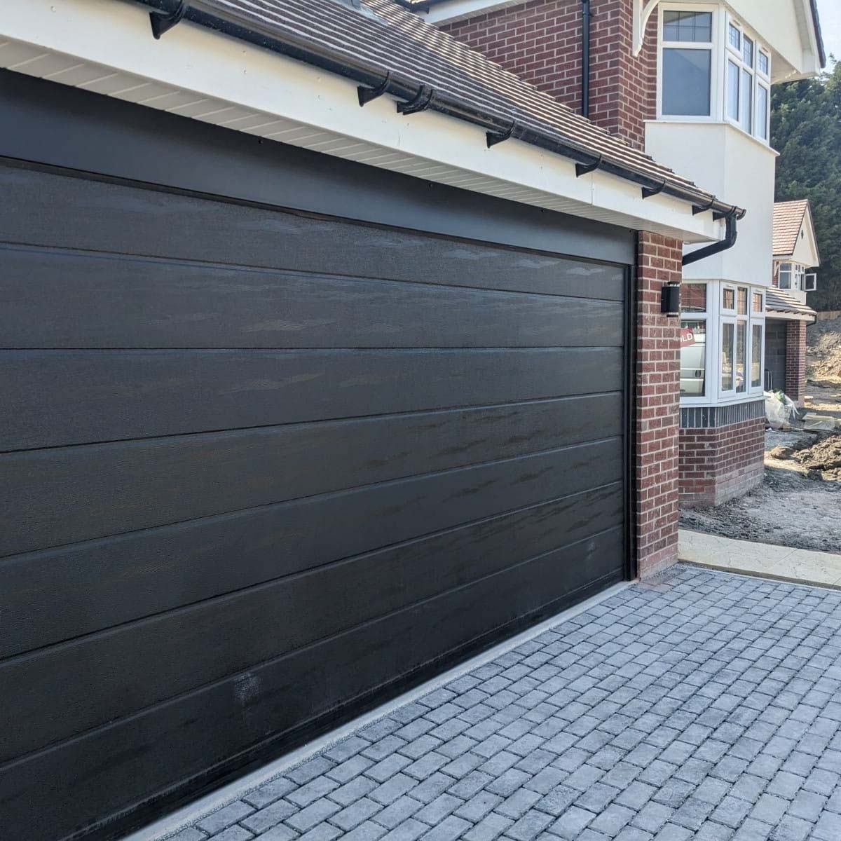 Black automatic sectional garage door in Telford